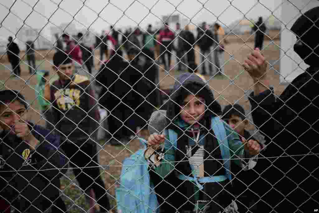 Displaced people wait for aid at a camp east of Mosul, Iraq.