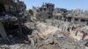 Palestinians gather at the site of destroyed houses in the aftermath of Israeli air and artillery strikes as cross-border violence between the Israeli military and Palestinian militants continues, in the northern Gaza Strip, May 14, 2021. 