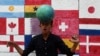 FILE - In this picture taken Nov. 7, 2022, a boy plays soccer in front of a wall mural ahead of the Qatar 2022 FIFA World Cup football tournament, along a street in Karachi. 