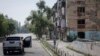 FILE - A Ukrainian police officer urges a resident to leave Toretsk before fierce fighting erupts. Russian troops said they have captured the village of Urozhayne in the Donestsk region.