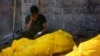 A man mourns by relatives' bodies — found under rubble or on the street — before their burial in Gaza City's al-Sinaa neighborhood, July 12, 2024, following the withdrawal of Israeli troops from the area.