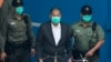 FILE - Jimmy Lai is escorted by Correctional Services officers to get on a prison van before appearing in a court in Hong Kong, Dec. 12, 2020.
