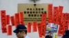 资料照片：2019年1月29日，警察在香港“中联办”外走过支持被监禁的中国人权律师王全璋的标语牌。（法新社照片）