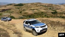 FILE - Cars of the European Border and Coast Guard Agency (FRONTEX) patrol at the Greece-Albania border, Sept. 4, 2019. The number of detected crossings into the EU "fell by 42% to 166,000 in the first nine months of this year," Frontex says.