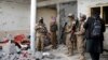 FILE - Taliban fighters inspect a house after a gunbattle erupted between Taliban and Islamic State group fighters, during a Taliban raid of a suspected hideout of IS militants on the outskirts of Jalalabad, Afghanistan, Nov. 30, 2021.