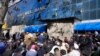 FILE - People wait to enter a bank, in Kabul, Afghanistan, Feb. 13, 2022. 