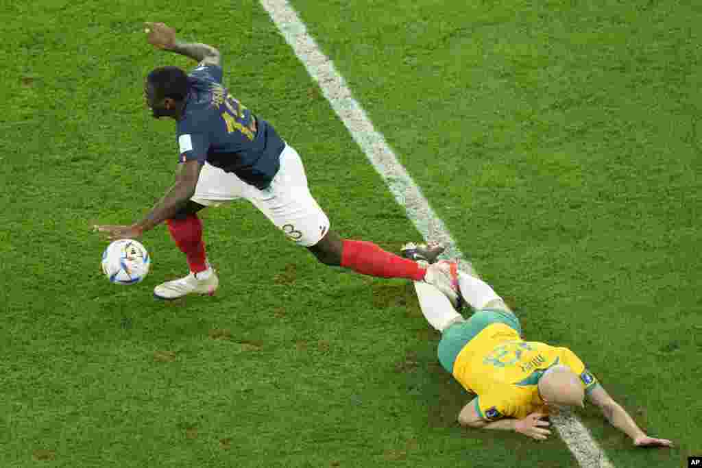 Franse Dayot Upamecano, a goch, ak Ostralyen Aaron Mooy goumen pou balon an pandan match La Frans kont Ostrali nan Mondyal Qatar la, 22 Nov. 2022.