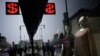 People walk past a currency exchange office screen displaying the exchange rates of U.S. Dollar and Euro to Russian Rubles in Moscow's downtown, Russia, March 29, 2022.
