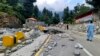 FILE - Local residents walk in the road destroyed by floodwaters in Kalam Valley in northern Pakistan, Sept. 4, 2022.
