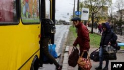 People board a bus leaving Severodonetsk, in eastern Ukraine's Donbass region, on April 13, 2022 as Russian troops intensified a campaign to take the strategic port city of Mariupol, part of an anticipated massive onslaught across eastern Ukraine. 