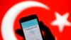 FILE - A person holds a mobile phone displaying a Twitter error message in front of Turkish national flag in this illustration taken in Zenica, March 21, 2014. 
