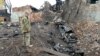 FILE - A Ukrainian serviceman looks at destructions following a shelling in Ukraine's second-biggest city of Kharkiv on March 7, 2022.