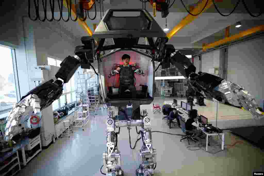 An employee controls the arms of a manned biped walking robot "METHOD-2" during a demonstration in Gunpo, South Korea.