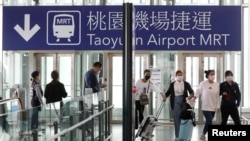 Travelers arrive at the airport as the Taiwanese government announced a ban for most foreigners entering the island, as part of preventive measures against coronavirus disease (COVID-19), at Taoyuan International airport in Taoyuan, Taiwan, March 18, 2020. REUTERS/Ann Wang
