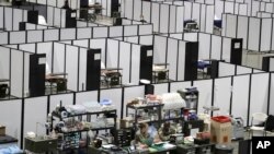 FILE - In this April 5, 2020, photo, soldiers work at a nursing station in the intensive care section of a military field at the CenturyLink Field Event Center in Seattle, Washington.
