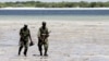 Somalia's Transitional Federal Government (TFG) soldiers patrol the Indian Ocean coastline in Burgabo, south of Kismayu in Somalia, December 14, 2011