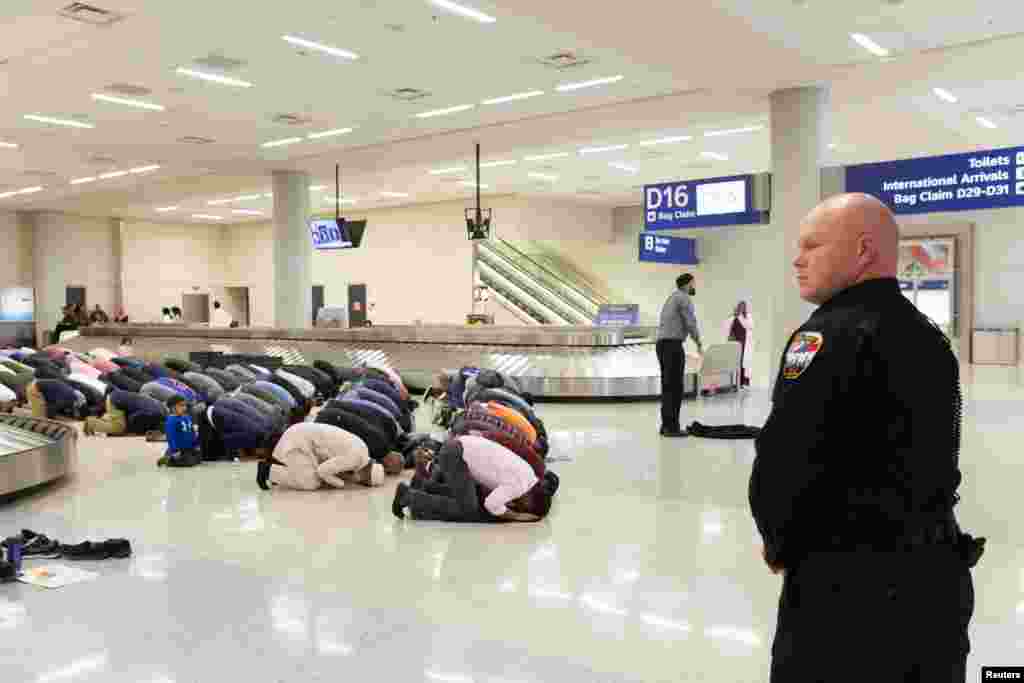 People gather to pray in baggage claim during a protest against the travel ban imposed by U.S. President Donald Trump&#39;s executive order, at Dallas/Fort Worth International Airport in Dallas, Texas, Jan. 29, 2017.