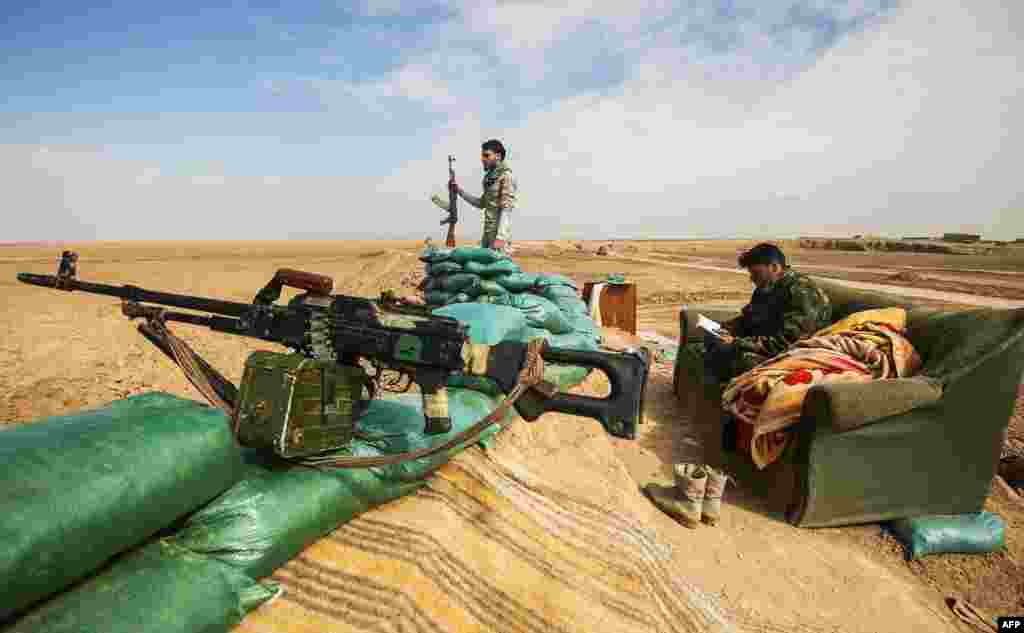 Fighters of the Hashed al-Shaabi paramilitaries stand guard by defensive positions near the frontline village of Shar&#39;iah, on the outskirts of Tal Afar west of Mosul.