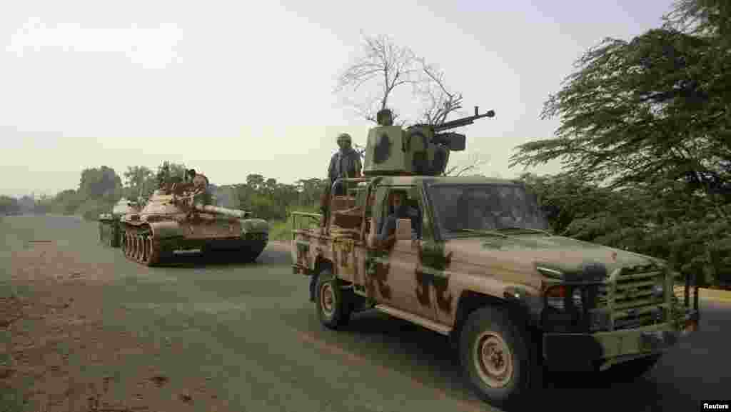 A military vehicle and tanks drive near the southern Yemeni city of Zinjibar after the army retook the city from al-Qaida-linked militants, June 12, 2012.