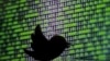 A 3D printed Twitter logo is seen in front of a displayed cyber code in this illustration taken March 22, 2016. 