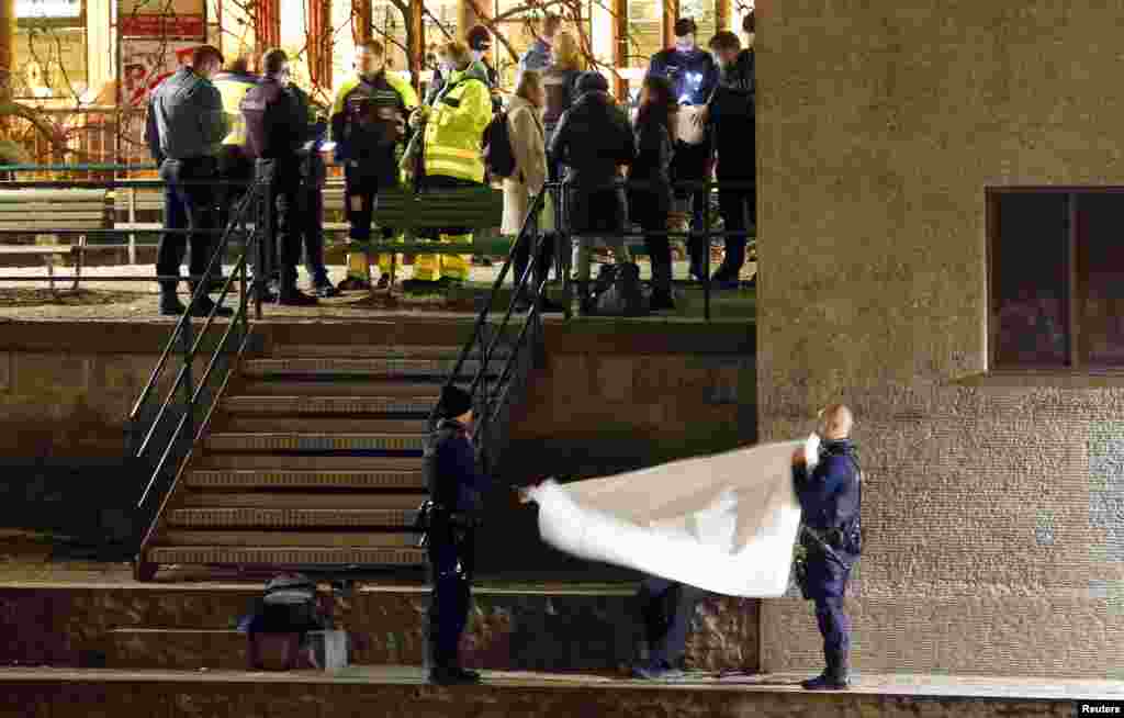 Police cover a body after a shooting outside an Islamic center in central Zurich, Switzerland, Dec. 19, 2016.