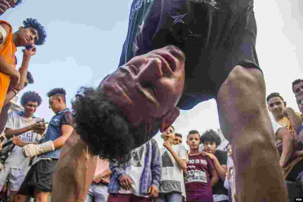 Young Egyptian men breakdance as a part of a show after Eid Al-Fitr prayers at Mostafa Mahmoud square in Cairo, Egypt, June 25, 2017. (H. Elrasam/VOA)