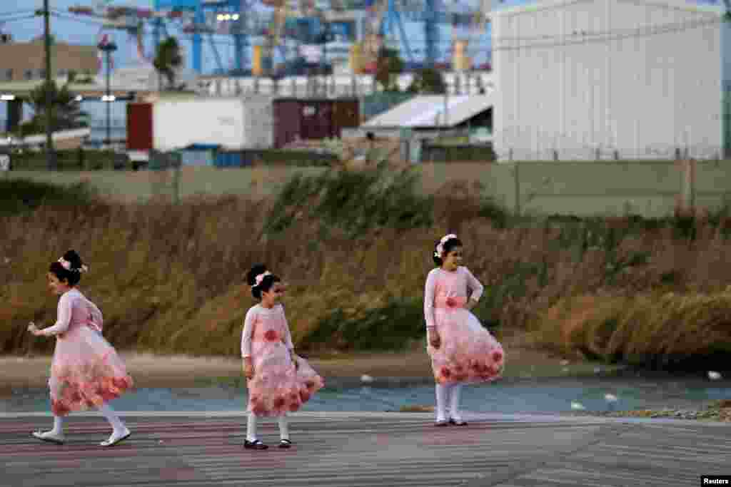Ultra-Orthodox Jewish girls pose for a photographer near the beach in the southern Israeli city of Ashdod, Dec. 13, 2016.