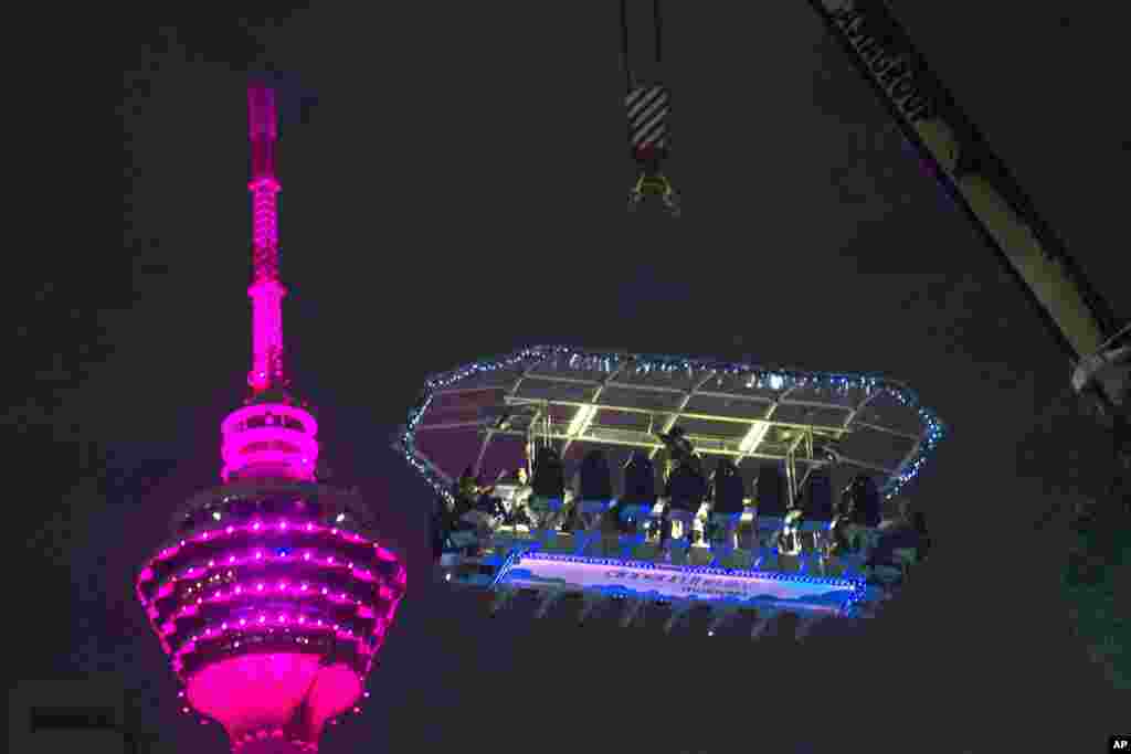 People dine at the "Dinner in the Sky" restaurant, overlooking the city center area with the Kuala Lumpur Tower in Malaysia.