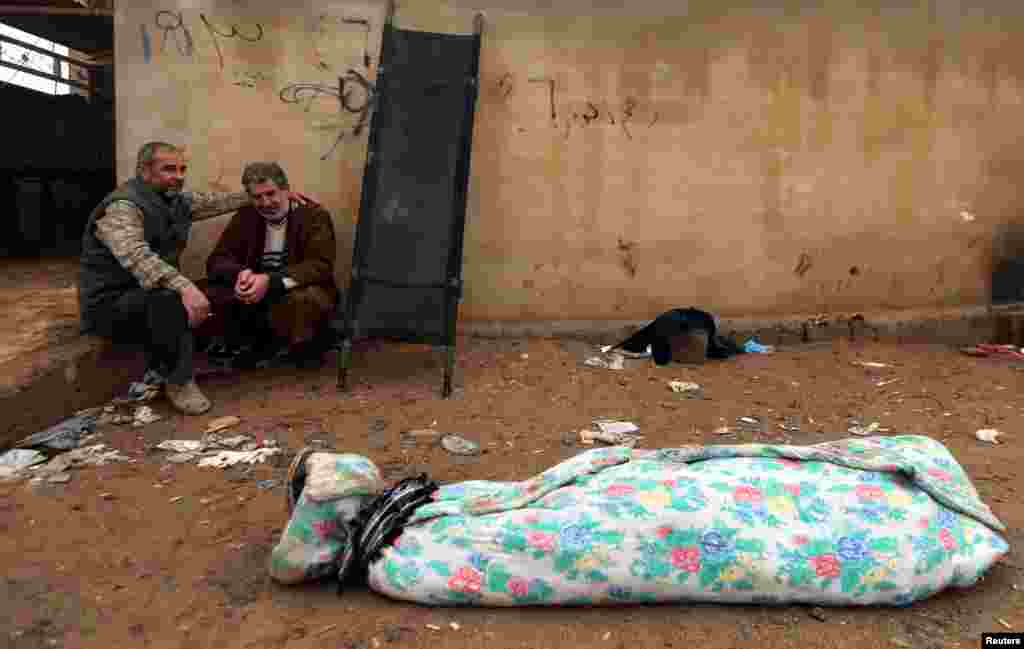 An Iraqi man (R) mourns near the body of his son, who was killed during clashes in the Islamic State stronghold of Mosul, in al-Samah neighborhood.