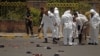 Forensic policemen inspect the site of a suicide bomb attack at a parade square in Sanaa, Yemen, May 21, 2012. 