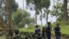 M23 rebel fighters watch the venue of a news conference by political leader Jean-Marie Runiga, in Bunagana, eastern DRC, in north Kivu province, July 21, 2012.