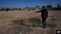 Një burrë tregon gropën e shkaktuar nga një raketë e mbushur me gazin sarin, gjatë sulmit me armë kimike në vitin 2013, i cili besohet të jetë kryer nga forcat e ish Presidentit Bashar al Assad, në paralagjet e Damaskut, më 25 dhjetor, 2024/Fotografi arkivi/AP