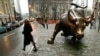 People pass the statue of the bull near Wall Street in New York, undated file photo.