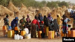 FILE - Women collect water at the Boudouri site for displaced persons outside the town of Diffa in southeastern Niger, June 21, 2016. 