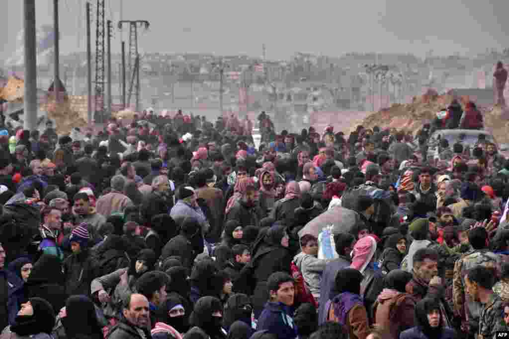 Syrian families, fleeing from various eastern districts of Aleppo, queue to get onto governmental buses in the government-held eastern neighborhood of Jabal Badro. The Syrian government offensive to recapture rebel-held Aleppo sparked international alarm, with the U.N. saying nearly 16,000 people had fled the assault and more could follow. 