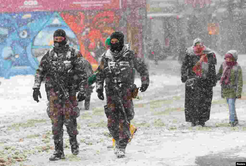 Members of police special forces patrol at the main shopping and pedestrian street of Istiklal during a snowfall in central Istanbul, Turkey.
