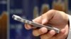 FILE - A man uses a smartphone in Tokyo, Japan, June 22, 2017. Visitors to New Zealand can now expect to be fined more than $3,000 for refusing to provide passwords to unlock electronic devices and allow customs officials to examine them under a new law condemned by civil liberties groups.