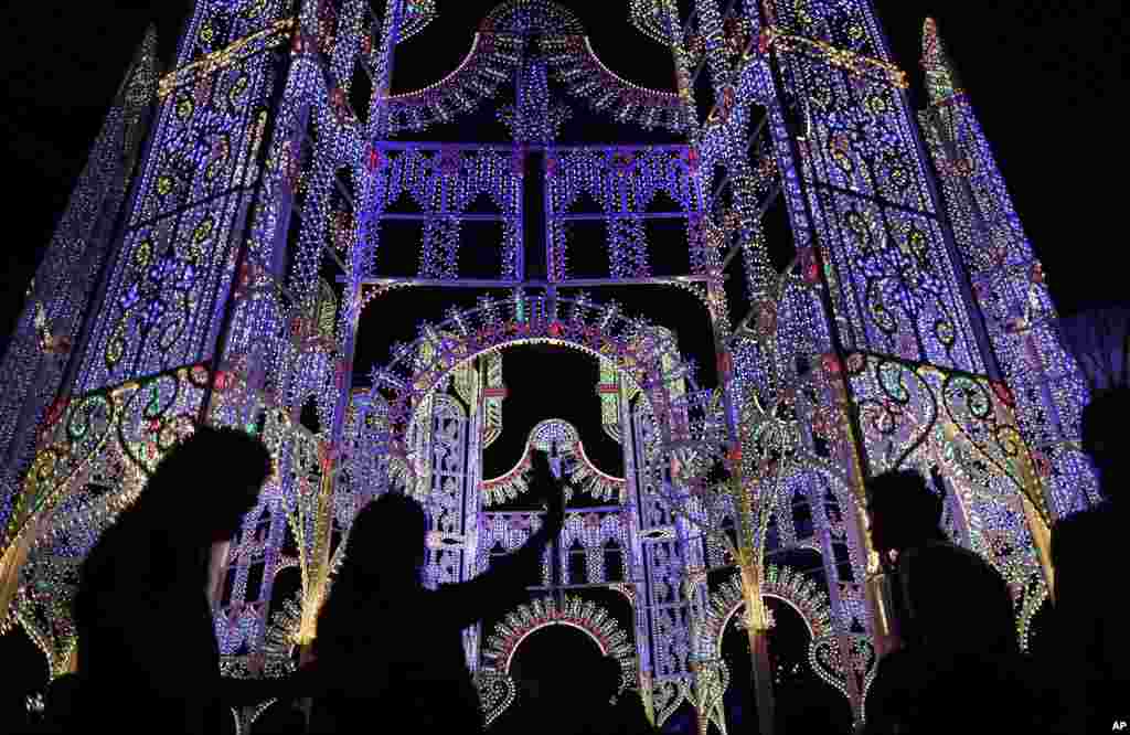 People are silhouetted against a giant light sculpture at the Gardens by the Bay in Singapore ahead of Christmas.