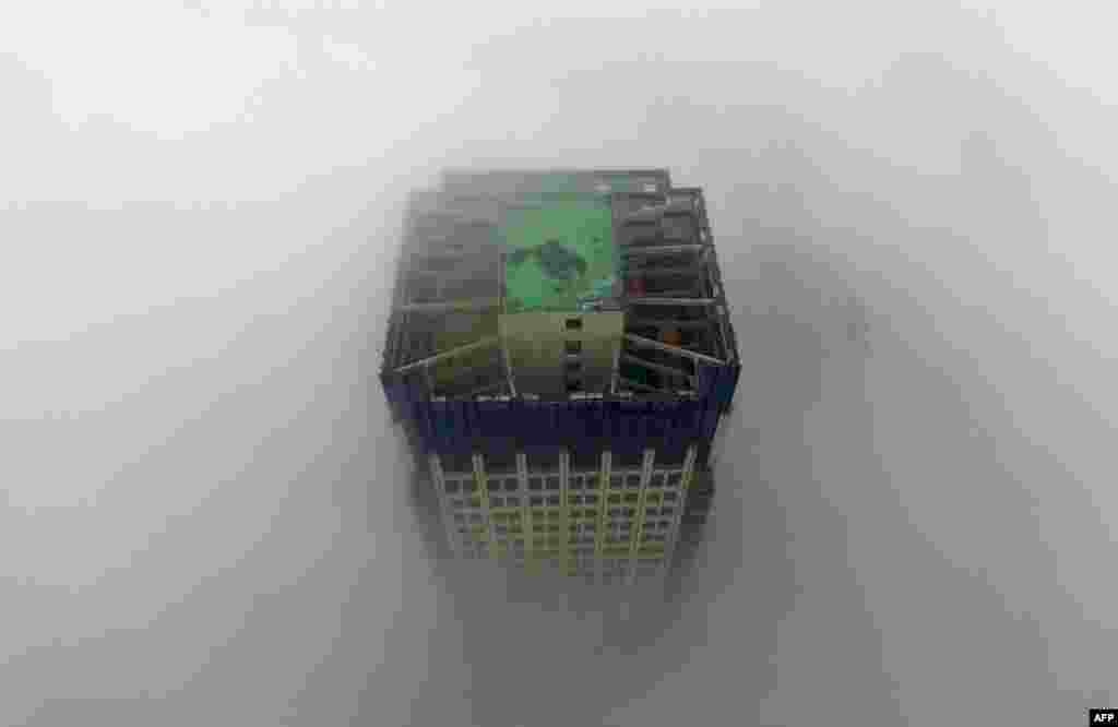 A building appears through a thick layer of fog in Yangzhou, in China's eastern Jiangsu province.