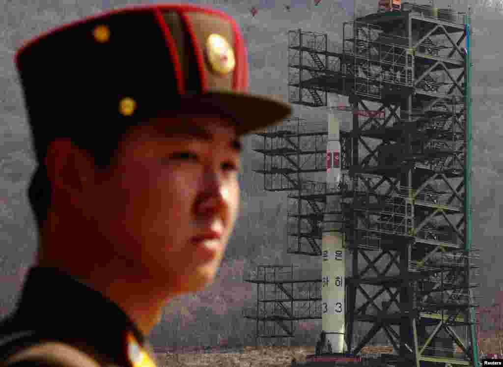 2012年4月8日，一名军人守卫在西海卫星发射基地银河三号火箭发射架前。这里位于首都平壤西北方。