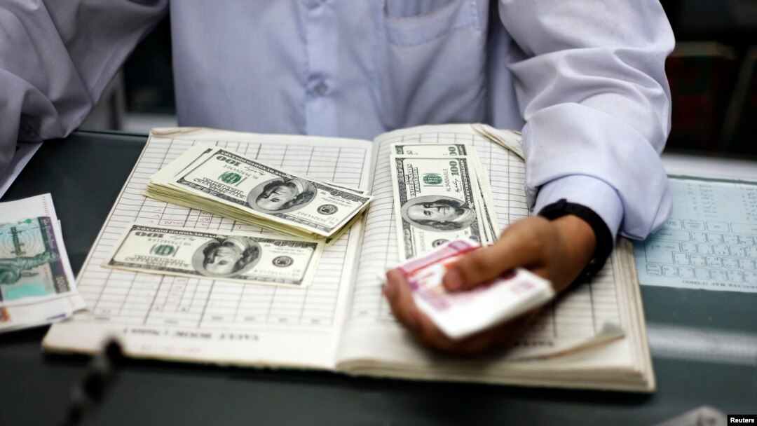 Myanmar man counts US dollars and Myanmar kyats
