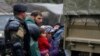 Macedonian soldiers escort migrants who have crossed the border illegally from Greece, into army trucks in the village of Moini, Macedonia, March 14, 2016. About 600 refugees who managed to cross over have been returned to greecce.