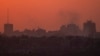 Destroyed buildings stand in the Gaza Strip as the sun sets, as seen from southern Israel on July 17, 2024.
