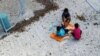 FILE - An undated supplied image from Amnesty International claiming to show children playing near a fence at the country's Australian-run detention centre on the Pacific island nation of Nauru. 