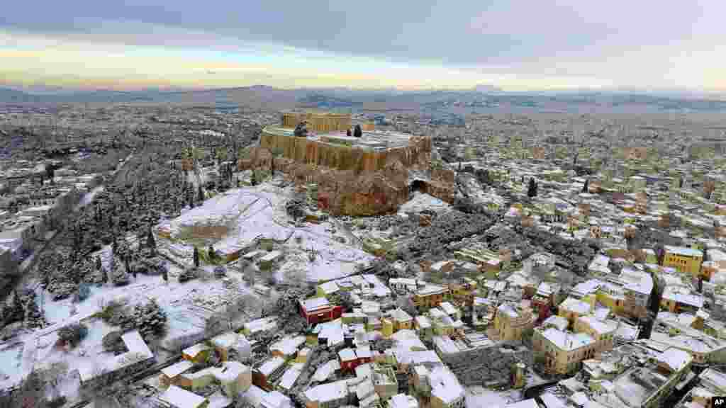 The Parthenon temple is seen atop of the snow-covered Acropolis hill in Athens, Greece.