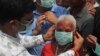 An Indian social activist distributes masks to pedestrians at the landmark Charminar in Hyderabad, India, March 5, 2020. 