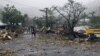FILE - People walk through debris in Samoa's capital Apia, Dec. 14, 2012, after cyclone Evan ripped through the South Pacific island nation. 