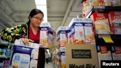 Chinese "daigou" shopping agent Na Wang selects an Australian breakfast cereal product popular in China, during a shopping trip for Chinese customers at an Australian supermarket in Sydney, Australia, Aug. 2, 2016.