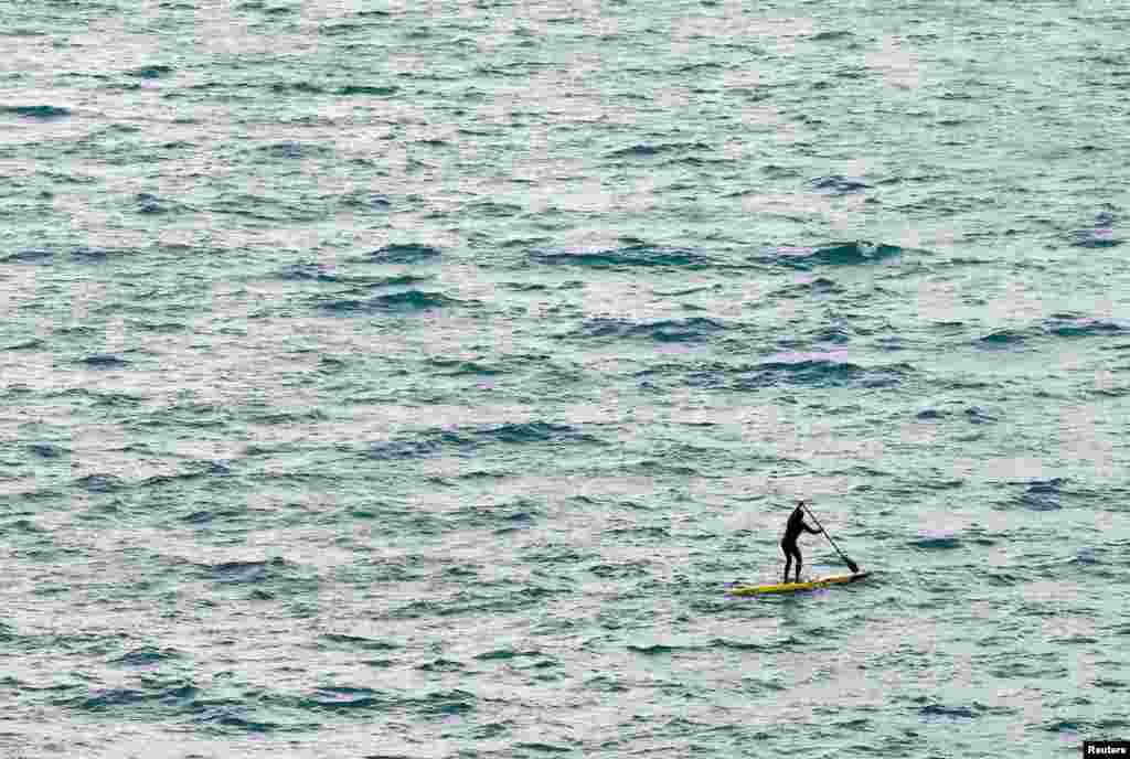 A man uses a stand-up paddle board during a windy day on Lake Leman in Cully, Switzerland.