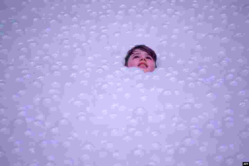 A child plays in an art installation called The Beach as they "float" on polyethylene balls as part of the annual Sydney Festival, Australia. The Beach at The Cutaway, Barangaroo Reserve, comprises 1.1 million recyclable polyethylene balls that create an ocean gently lapping against a 60-meter-wide shoreline free of sand created by New York-based design studio Snarkitecture.